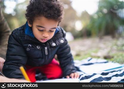 Portrait of cute african american little boy having fun and playing outdoors in the park.