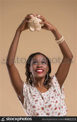 Portrait of cute african woman posing - holding piggy moneybox