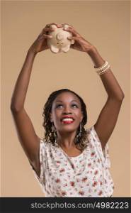 Portrait of cute african woman posing - holding piggy moneybox