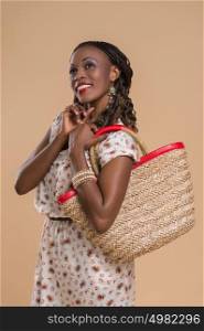Portrait of cute african woman posing - standing with straw bag