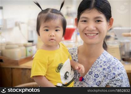 Portrait of cute Asian baby girl and mom at home