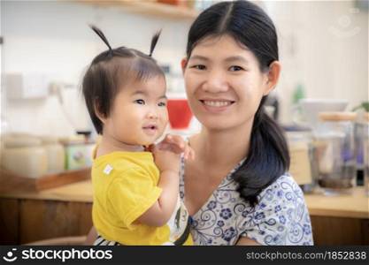 Portrait of cute Asian baby girl and mom at home