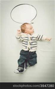 Portrait of cute baby boy posing with empty speech bubble