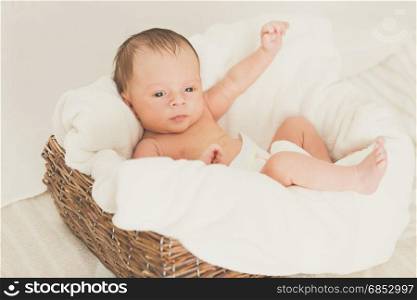 Portrait of cute baby boy with blue eyes lying on cushions
