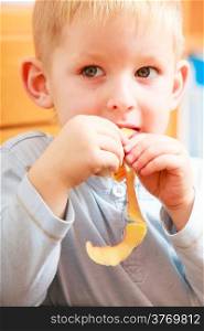 Portrait of cute blond child boy kid preschooler eating apple peel. Healthy diet and nutrition. At home.
