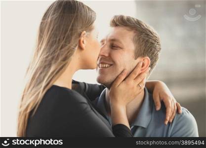 Portrait of cute blonde woman hugging happy boyfriend and kissing in nose