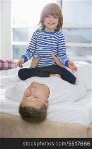 Portrait of cute boy playing with father in bedroom