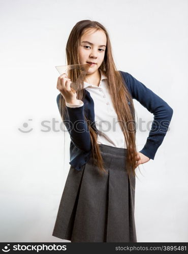 Portrait of cute brunette schoolgirl posing with plastic protractor