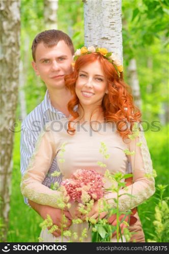 Portrait of cute cheerful couple hugging in the forest, happy wedding day, romantic feelings, new family concept
