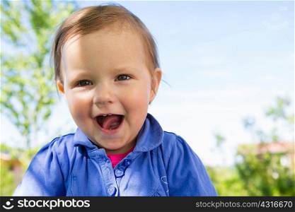 Portrait of cute female toddler in garden