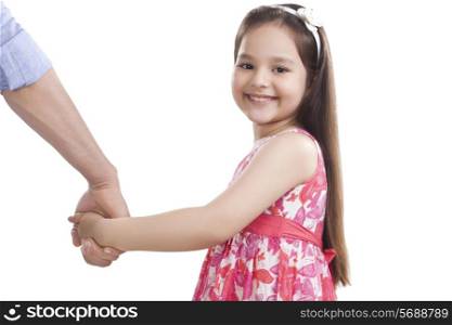 Portrait of cute girl holding father&rsquo;s hand against white background