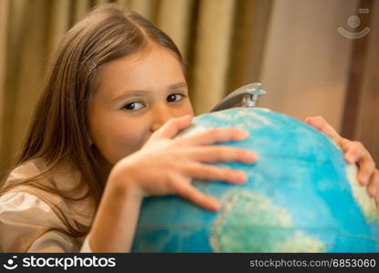 Portrait of cute girl holding hand on Earth globe