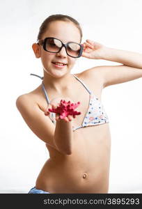 Portrait of cute girl in sunglasses showing red starfish on hand