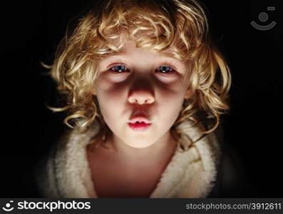 Portrait of cute girl looking at camera with frightening expression