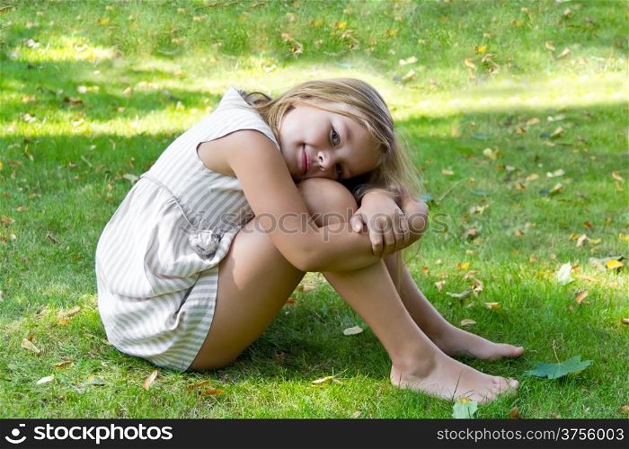 Portrait of cute girl sitting on green grass