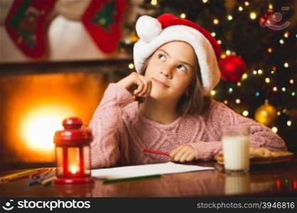 Portrait of cute girl thinking of letter to Santa at living room