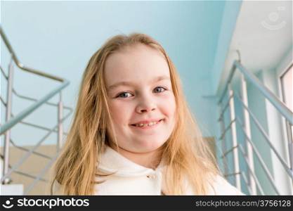 Portrait of cute girl with blond hair in white