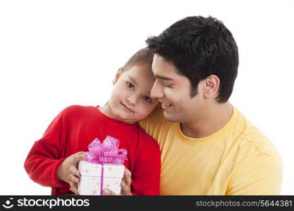 Portrait of cute girl with father holding gift