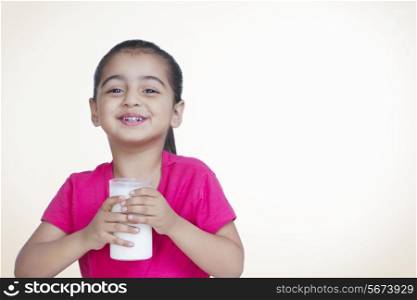 Portrait of cute girl with glass of milk against colored background