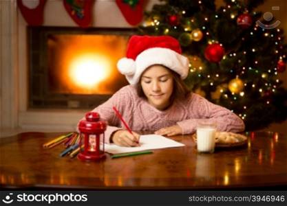 Portrait of cute girl writing letter to Santa at living room