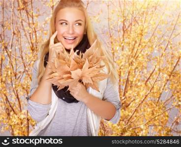 Portrait of cute happy girl with dry maple leaves bouquet in the park, spending time outdoors, enjoying autumn concept