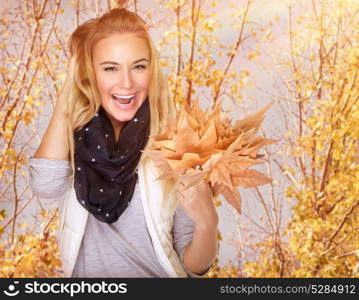 Portrait of cute happy girl with dry maple leaves bouquet in the park, spending time outdoors, enjoying autumn concept