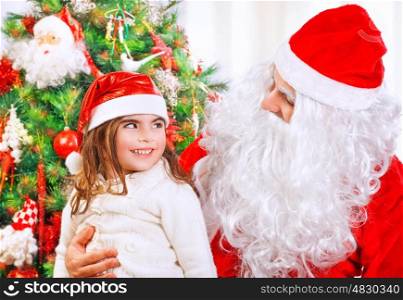 Portrait of cute happy little girl with Santa Claus sitting at home near beautiful decorated Christmas tree, happy spending winter holidays