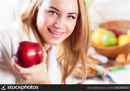 Portrait of cute happy woman eating red ripe apple for breakfast, fruit diet, organic nutrition, healthy lifestyle
