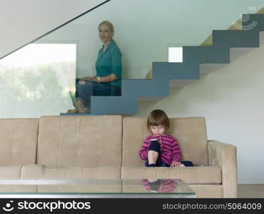 Portrait of cute little girl playing games on smartphone at home