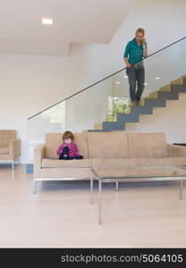 Portrait of cute little girl playing games on smartphone at home