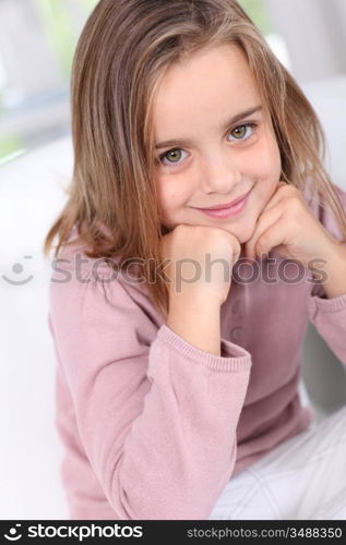 Portrait of cute little girl with hands on chin