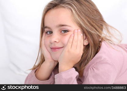 Portrait of cute little girl with hands on chin