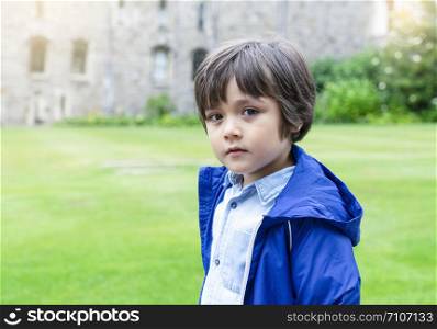 Portrait of cute little looking at camera standing in the castle, Preschool kid playing outdoor next to museum, Child learn and play concept