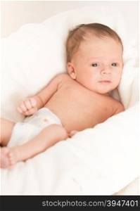Portrait of cute newborn baby with blue eyes lying in basket
