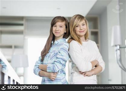 Portrait of cute sisters standing together at home