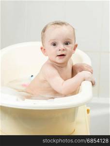 Portrait of cute smiling boy sitting in bath