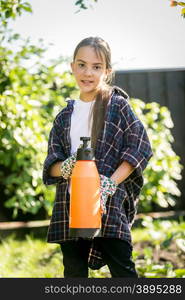 Portrait of cute smiling girl posing at garden with spray