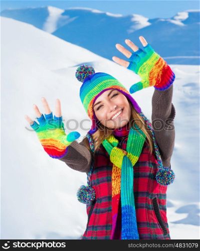 Portrait of cute smiling girl waving hands, wearing stylish colorful outfit, spending active winter holidays in the snowy mountains&#xA;