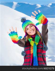 Portrait of cute smiling girl waving hands, wearing stylish colorful outfit, spending active winter holidays in the snowy mountains&#xA;