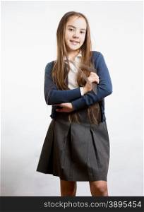 Portrait of cute smiling schoolgirl holding plastic ruler against white background