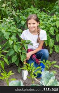 Portrait of cute teenage girl planting plants at garden