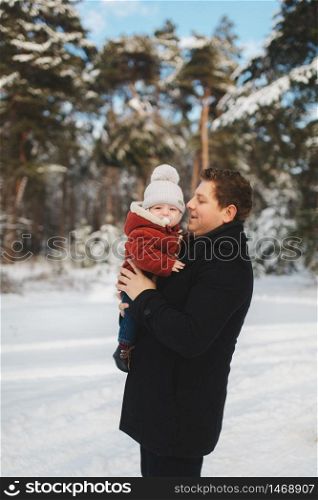 portrait of dad with baby son in winter forest. family has a good time together.. portrait of dad with baby son in winter forest. family has a good time together