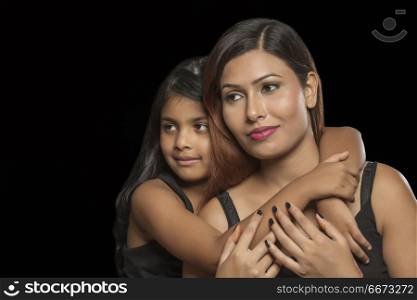 Portrait of daughter embracing her mother from behind