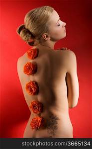 portrait of deaming cute girl with closed eyes on red background with some flowers on her back
