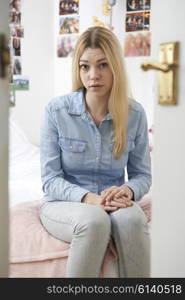 Portrait Of Depressed Teenage Girl In Bedroom