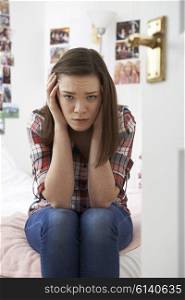 Portrait Of Depressed Teenage Girl In Bedroom