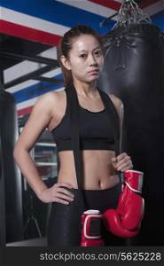 Portrait of determined female boxer with boxing gloves looking at camera