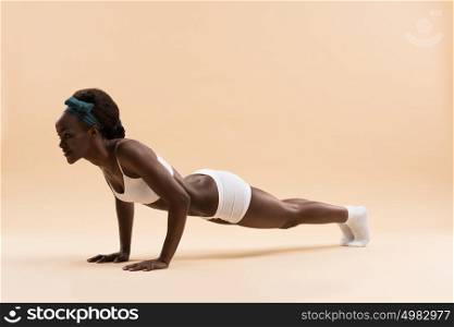 Portrait of determined young african woman doing push ups