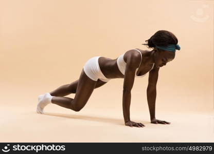 Portrait of determined young african woman doing push ups