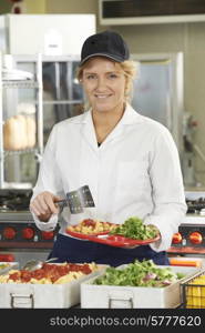 Portrait Of Dinner Lady Serving Meal In School Cafeteria